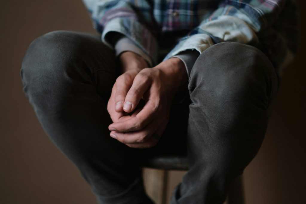 Homme assis les mains jointes en prière — apprendre à prier avec autorité et confiance