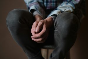 Homme assis les mains jointes en prière — apprendre à prier avec autorité et confiance